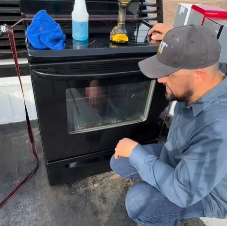 Technician repairing a gas and electric stove with burners that are not working in Klamath Falls, OR.