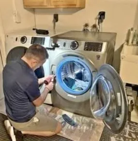 Technician repairing a washing machine with excessive noise and vibration in Klamath Falls, OR.