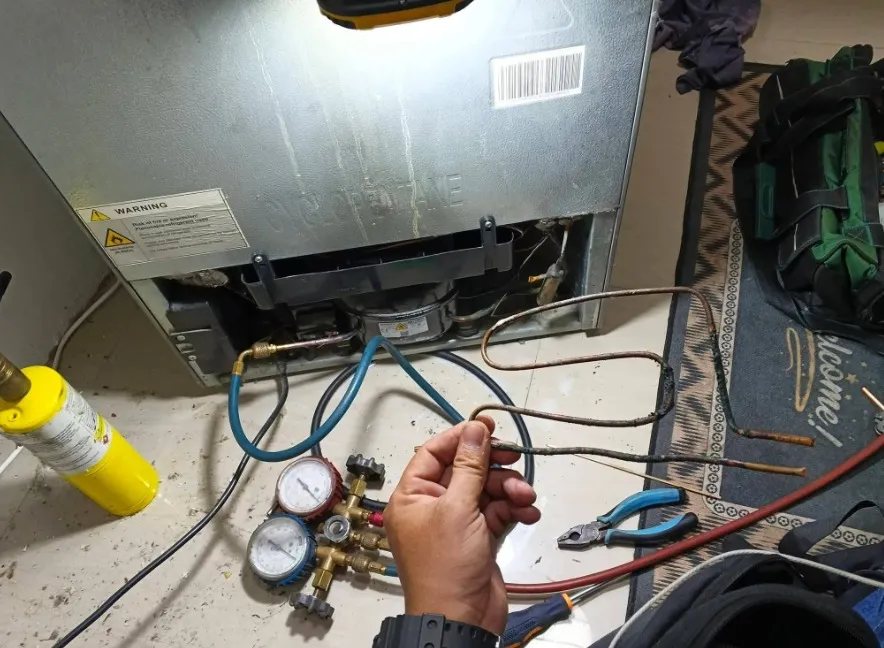 Technician repairing a refrigerator ice maker that is not working in Klamath Falls, OR.