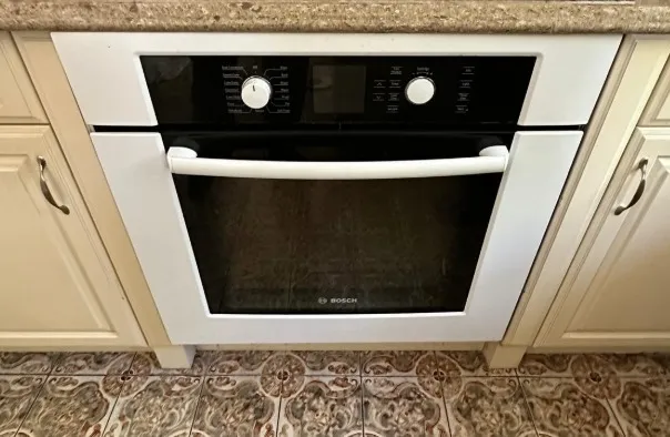 Professional technician repairing a stove that won't turn on in a Klamath Falls, OR kitchen.